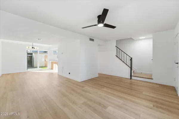 a view of a room with wooden floor and a ceiling fan