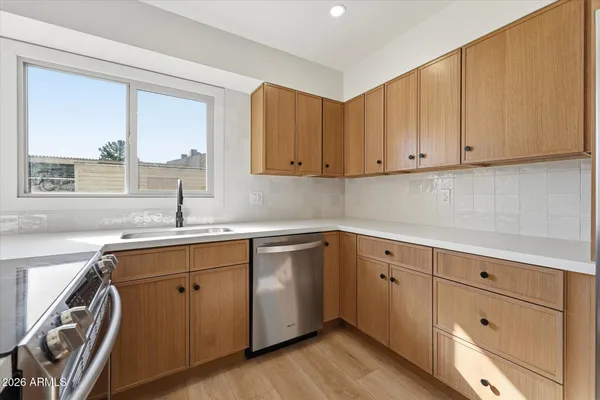 a kitchen with stainless steel appliances granite countertop a sink stove and cabinets
