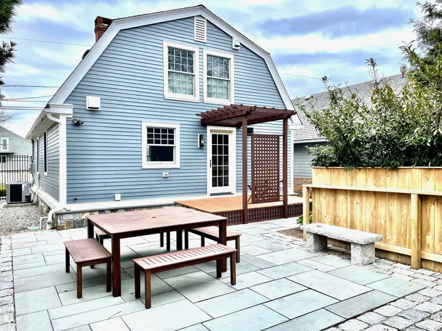 a backyard of a house with barbeque oven table and chairs