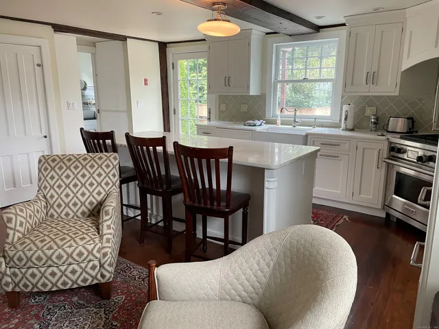 a living room with furniture a large window and a wooden floor