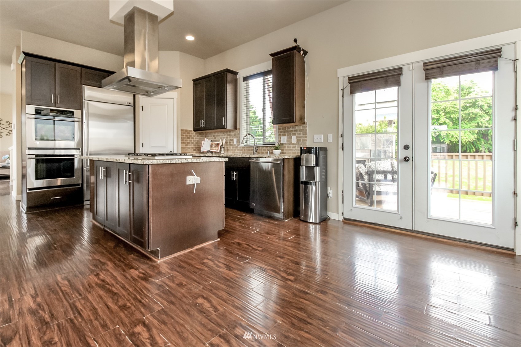 889 Lund Street Buckley, WA 98321 - Photo 14 of 40 a kitchen with stainless steel appliances granite countertop a refrigerator a sink dishwasher a stove and a dining table with wooden floor