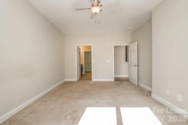 a view of an empty room with a chandelier fan