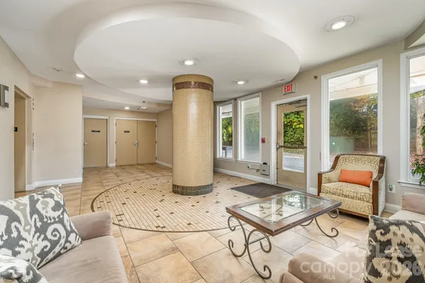 a living room with furniture and a floor to ceiling window