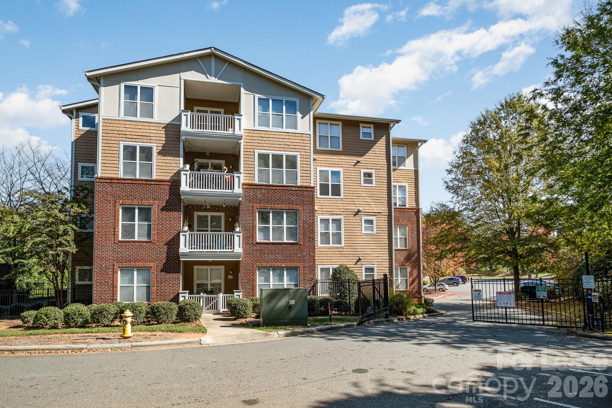 1000 East Woodlawn Road, Unit 201 Charlotte, NC 28209 - Photo 28 of 29 a front view of a building with lot of cars and trees