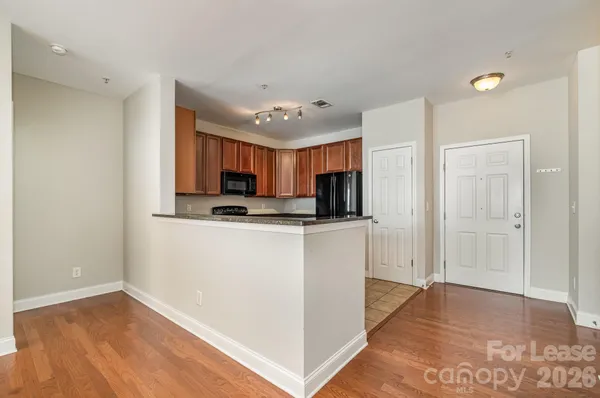 a view of kitchen with stainless steel appliances cabinets and wooden floor