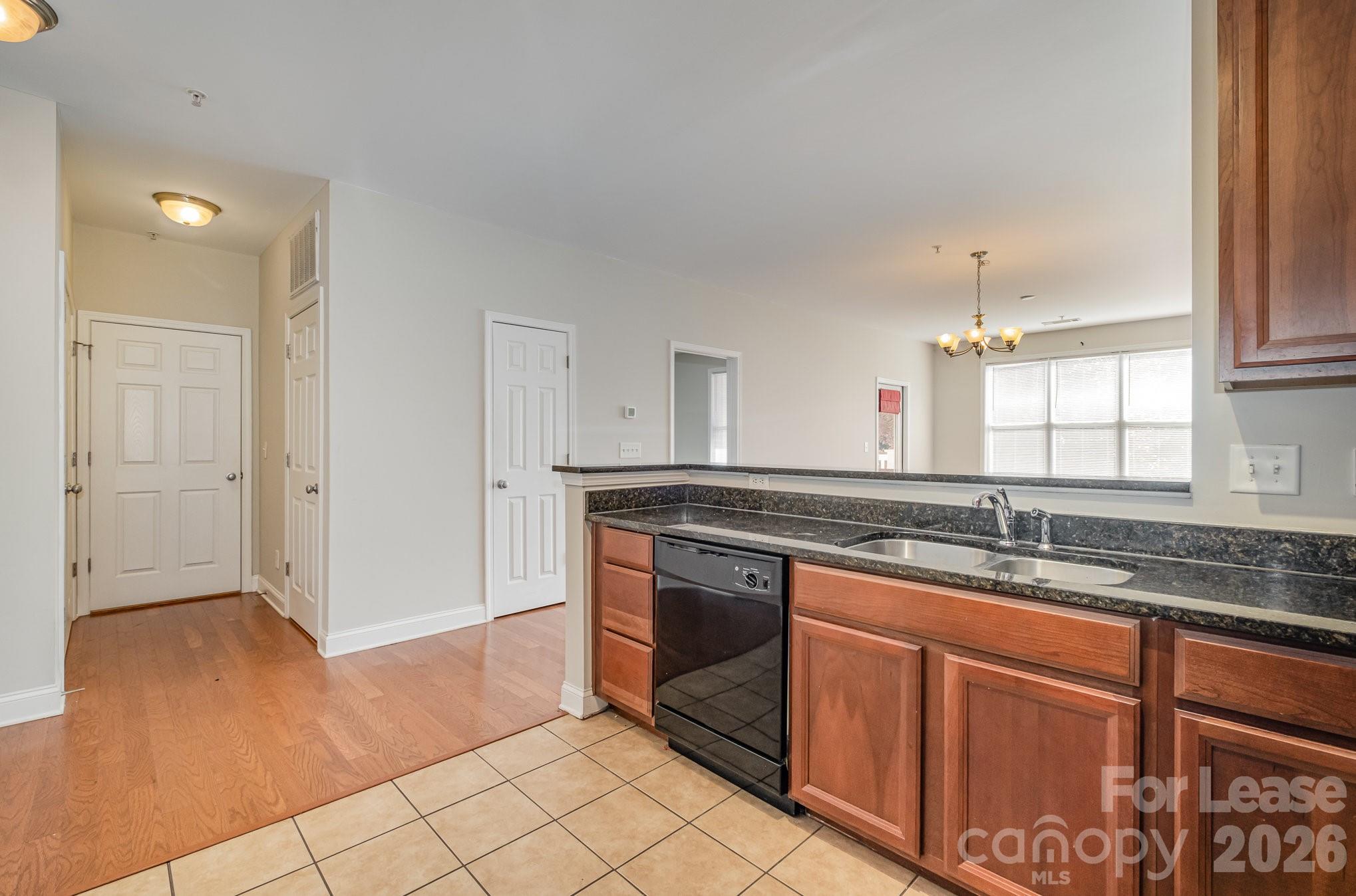 1000 East Woodlawn Road, Unit 201 Charlotte, NC 28209 - Photo 7 of 29 a kitchen with stainless steel appliances granite countertop a sink stove and cabinets