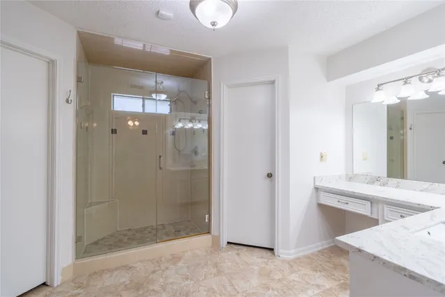 a bathroom with a granite countertop sink mirror and shower