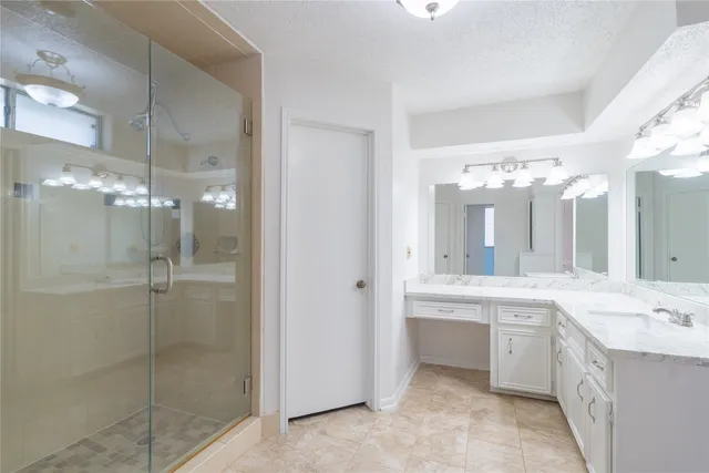 a bathroom with a double vanity sink mirror and shower