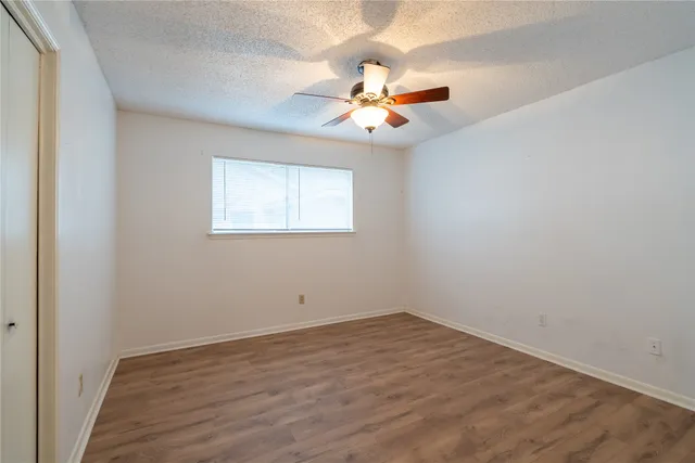an empty room with a window and a fan