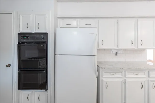 a white refrigerator freezer and a stove sitting inside of a kitchen