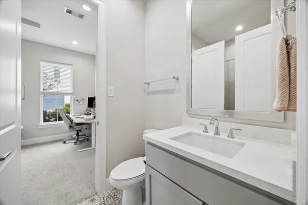 a bathroom with a sink a toilet and a mirror