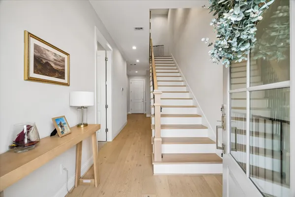 a view of a hallway with wooden floor and windows