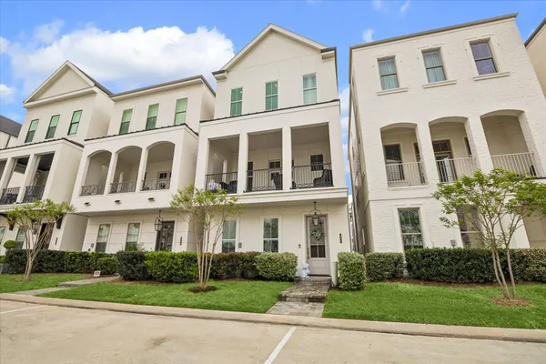 a front view of a residential apartment building with yard and green space