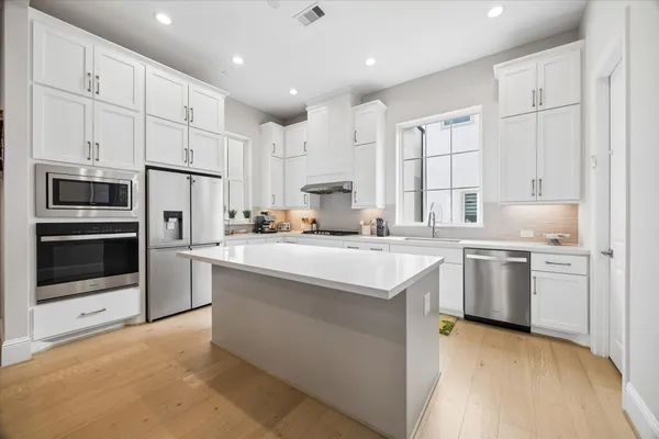 a kitchen with stainless steel appliances a refrigerator sink and cabinets
