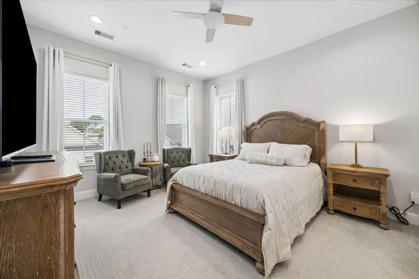 a spacious bedroom with a bed and a flat screen television