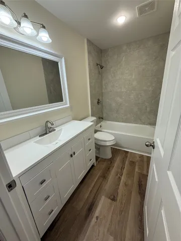 a bathroom with a double vanity sink toilet mirror and bathtub