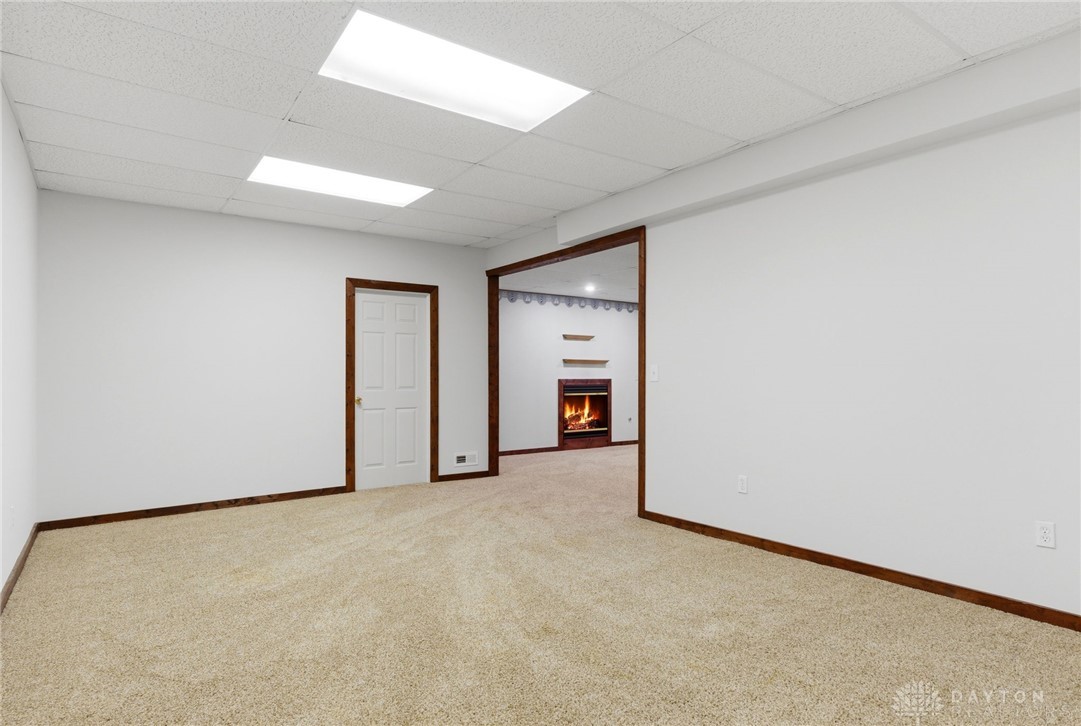 1540 Jasper Road Xenia, OH 45385 - Photo 55 of 91 This versatile recreation room features warm carpeting and an inviting fireplace, perfect for relaxation or entertainment.