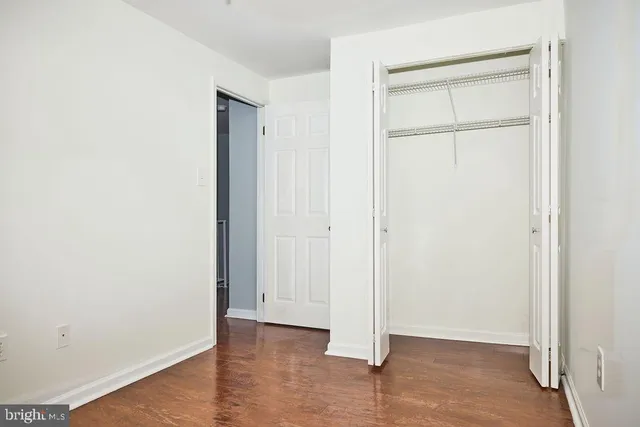 an empty room with a window and a chandelier fan