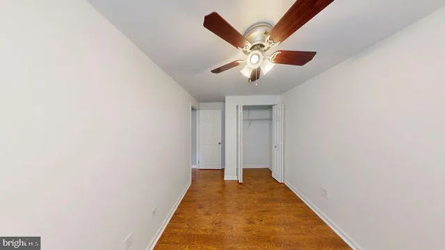 a view of a hallway with a chandelier fan and wooden floor