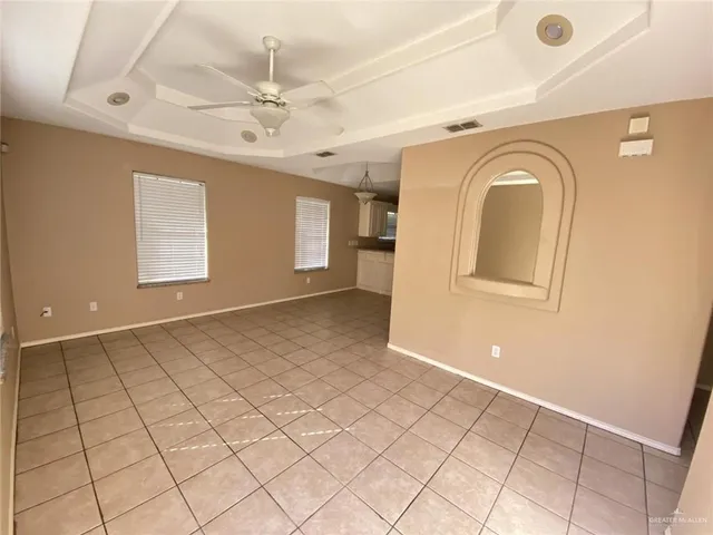 an empty room with windows and fan