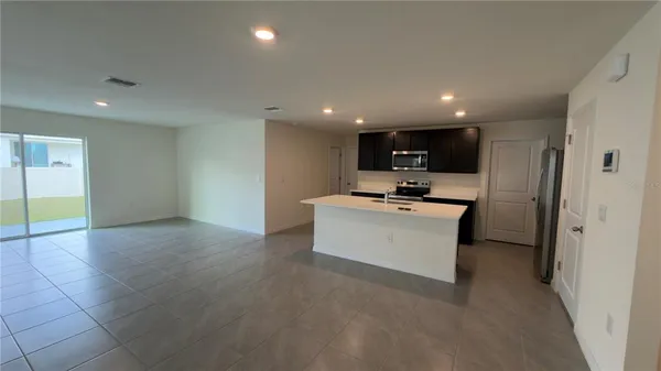 a view of kitchen with refrigerator stove microwave and cabinets