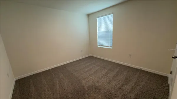 an empty room with closet and a bathroom