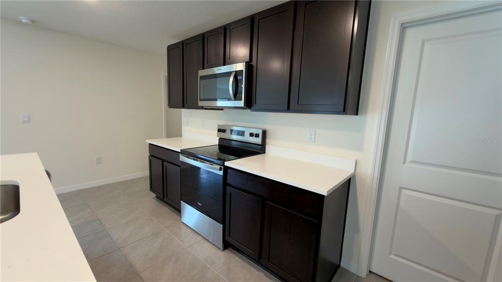 8632 Southwest 45th Court Ocala, FL 34476 - Photo 6 of 41 a kitchen with a stove and a microwave