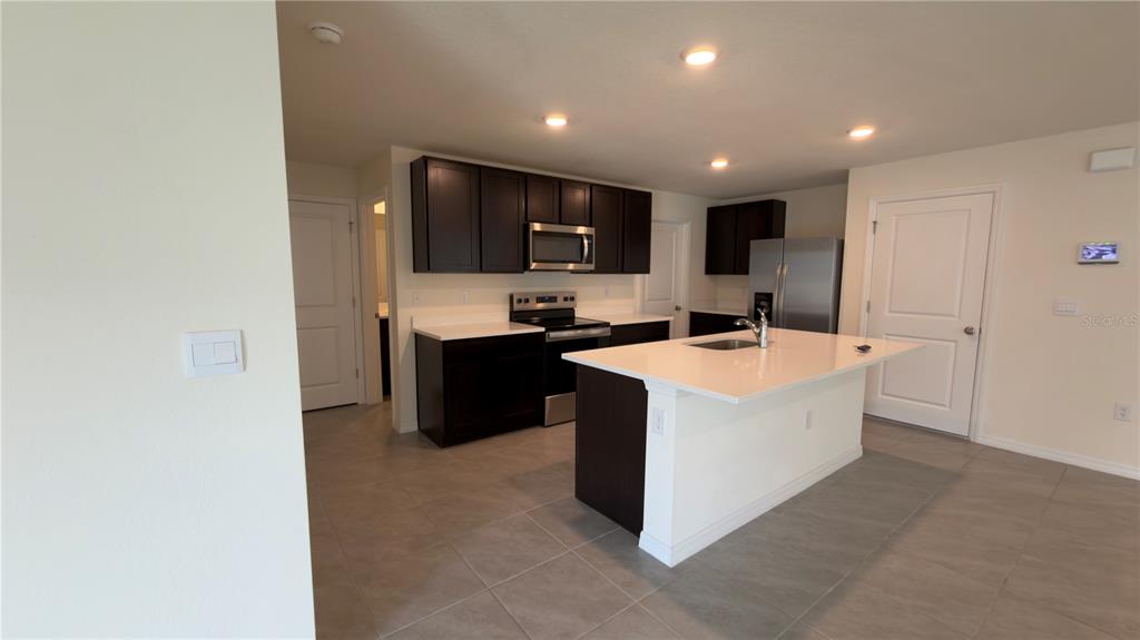 8632 Southwest 45th Court Ocala, FL 34476 - Photo 10 of 41 a kitchen with stainless steel appliances a sink stove and cabinets