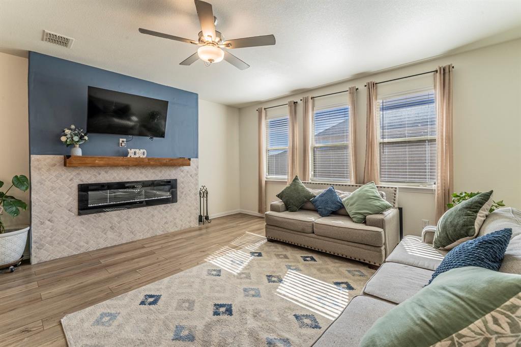 1240 Almond Road Azle, TX 76020 - Photo 2 of 26 a living room with furniture a flat screen tv and a fireplace
