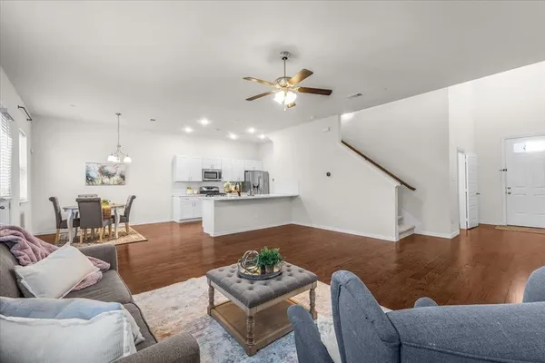 a living room with furniture kitchen view and a chandelier