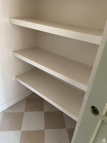 4676 West 75 North, Unit 401 West Point, UT 84015 - Photo 6 of 17 Built-in shelving unit featuring three expansive shelves, white baseboards, and two-tone checkered floor tiles