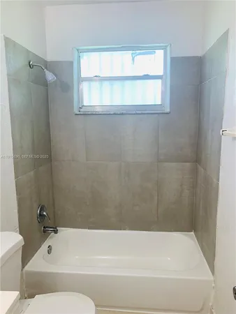 a bathroom with a bathtub and a window
