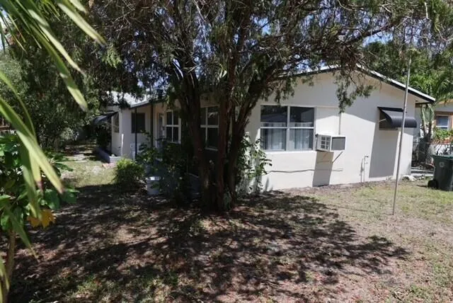 a white house that has a tree in front of the house