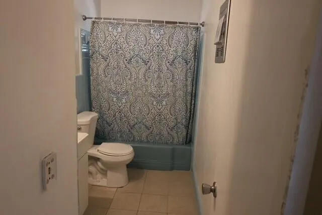 a bathroom with a toilet and a shower curtain