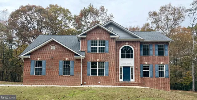 a front view of a house with yard and green space