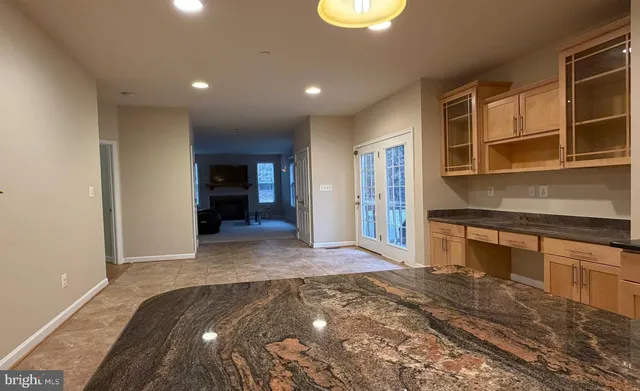 a view of a kitchen with kitchen island a sink wooden floor and living room