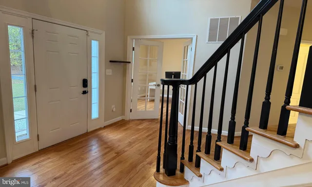 a view of an entryway with wooden floor and stairs