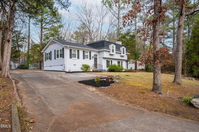 a front view of a house with a yard and trees