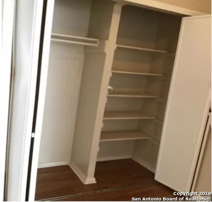 a view of walk in closet with empty racks