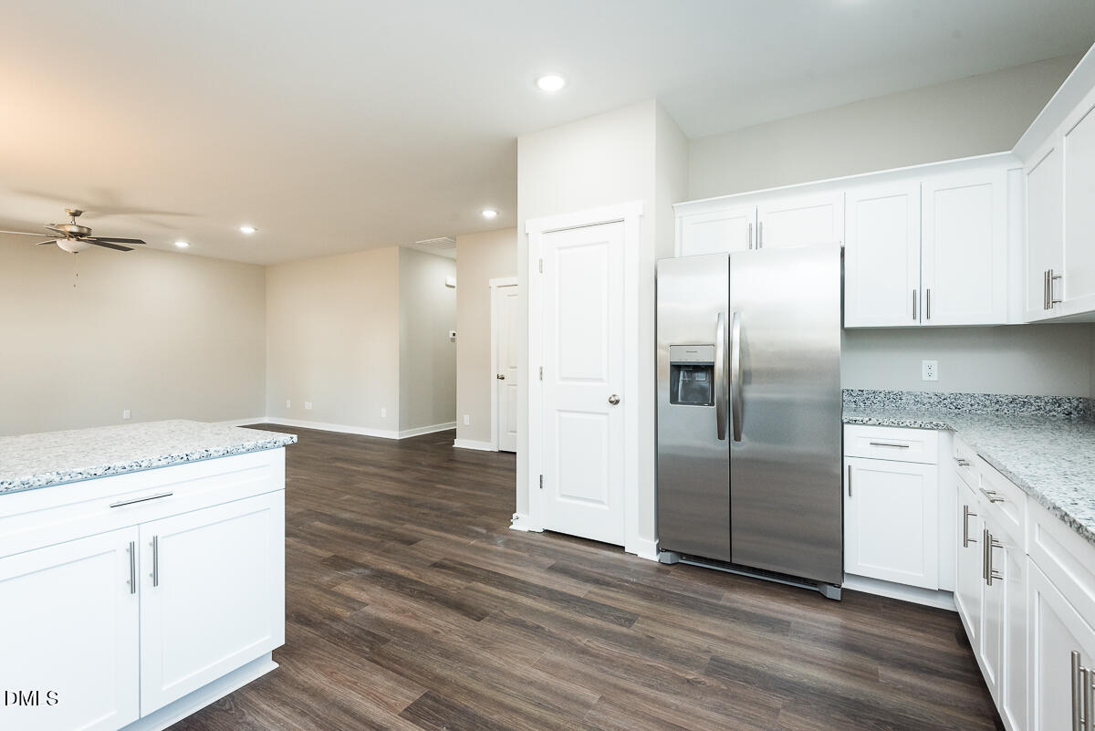 2828 Ricolden Trail Elon, NC 27244 - Photo 4 of 14 a kitchen with granite countertop a refrigerator and white cabinets
