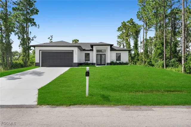 a front view of a house with a garden and yard
