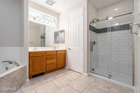 a bathroom with a double vanity sink mirror and shower