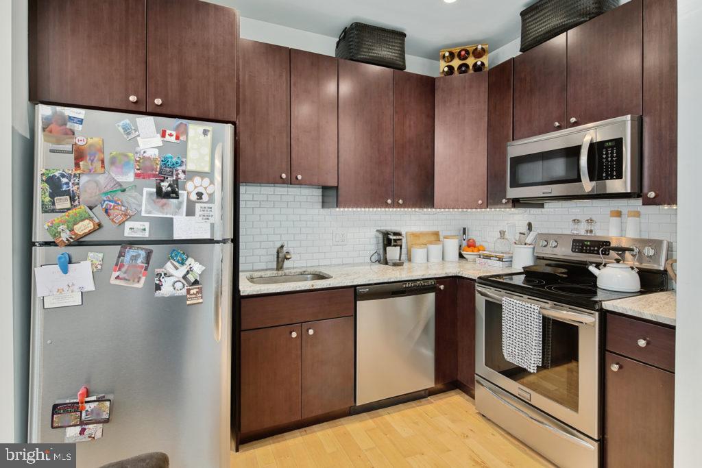 a kitchen with stainless steel appliances granite countertop a refrigerator and a sink
