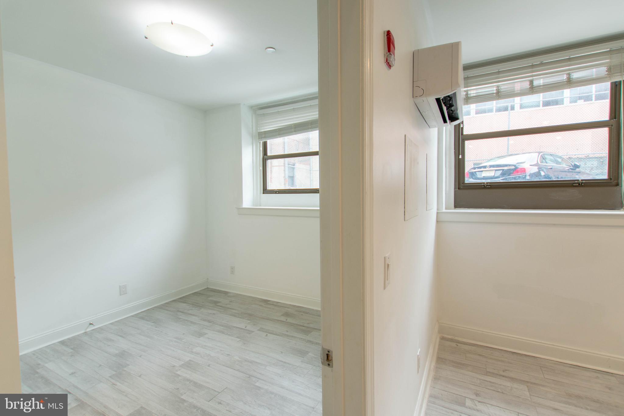427-33 Monroe Street, Unit 102 Philadelphia, PA 19147 - Photo 11 of 23 an empty room with wooden floor and windows