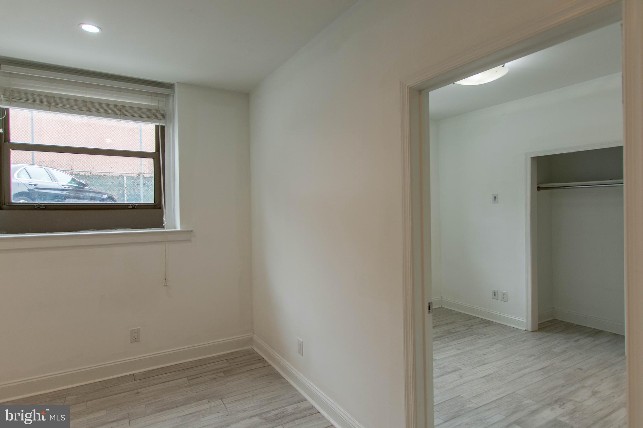 427-33 Monroe Street, Unit 102 Philadelphia, PA 19147 - Photo 17 of 23 an empty room with wooden floor and windows