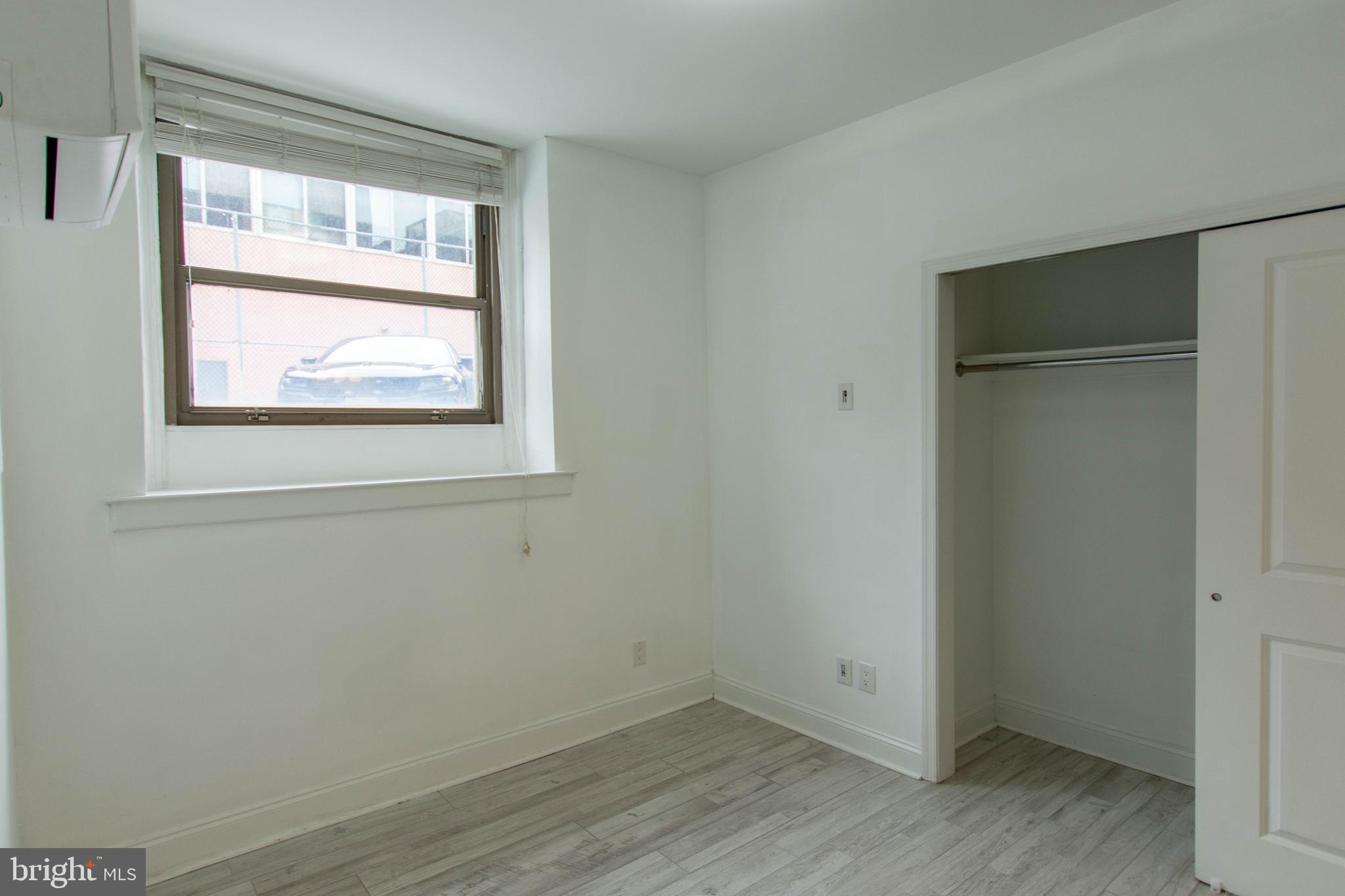 427-33 Monroe Street, Unit 102 Philadelphia, PA 19147 - Photo 18 of 23 a view of an empty room with wooden floor and a window