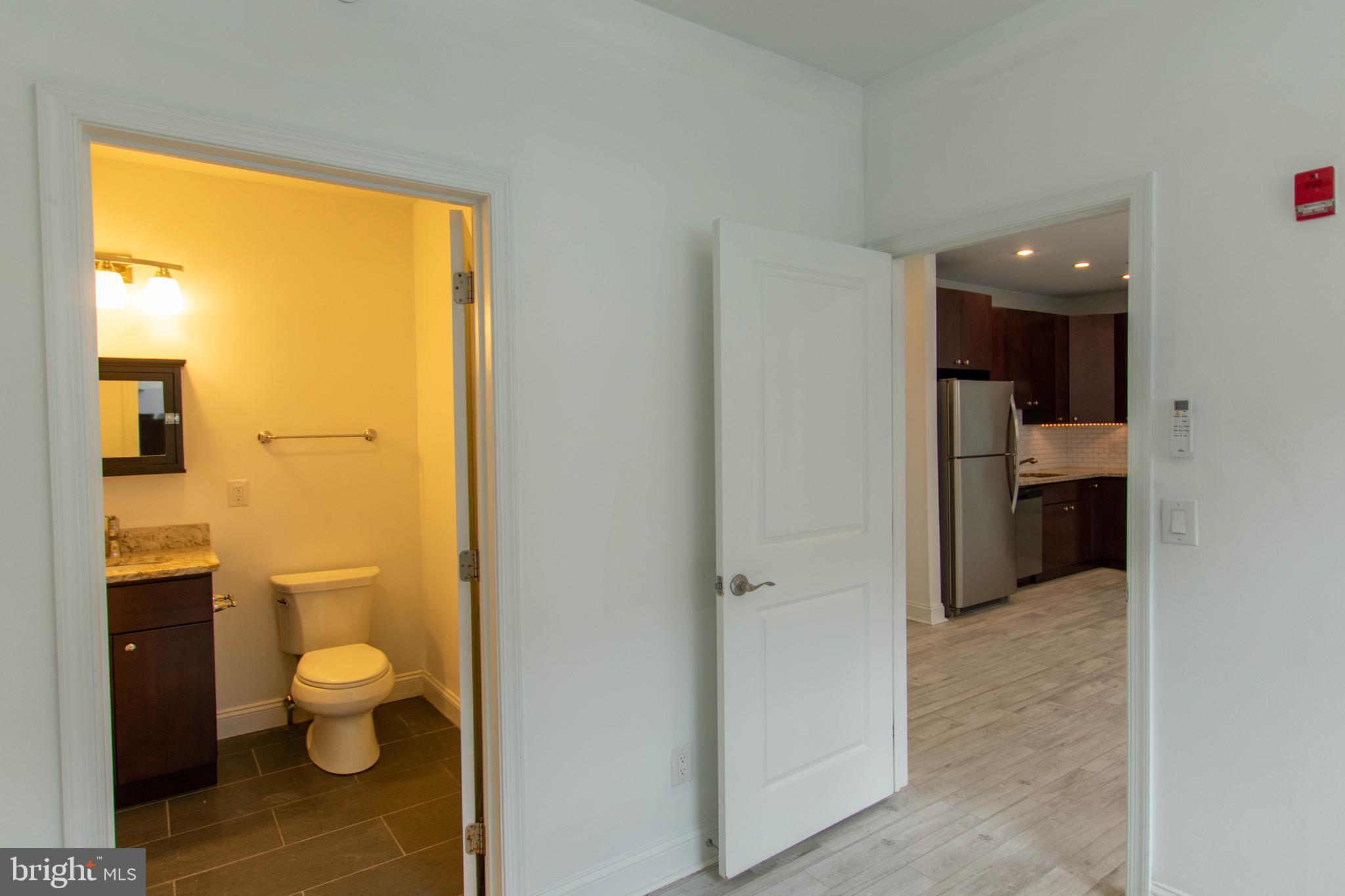 427-33 Monroe Street, Unit 102 Philadelphia, PA 19147 - Photo 20 of 23 a bathroom with a granite countertop toilet a sink and a mirror