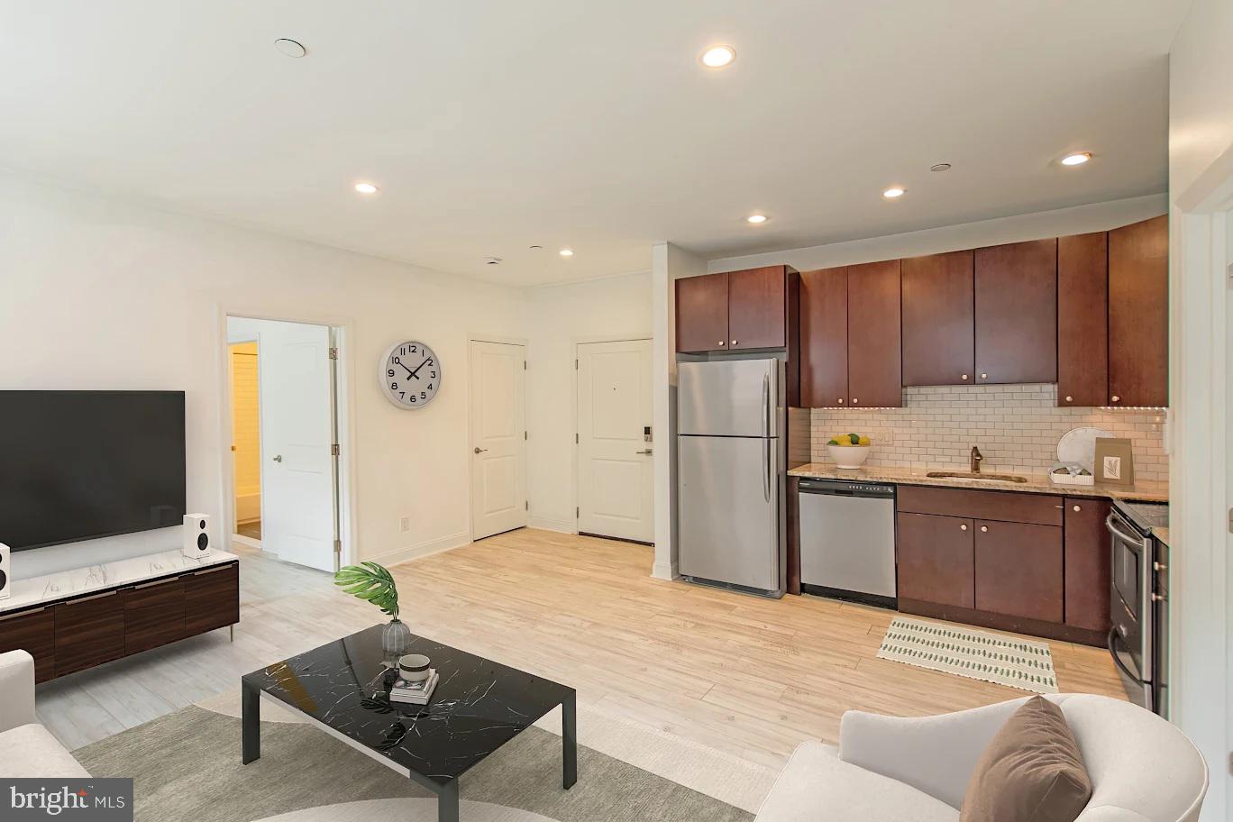 427-33 Monroe Street, Unit 102 Philadelphia, PA 19147 - Photo 2 of 23 a kitchen with stainless steel appliances kitchen island granite countertop a refrigerator and a stove top oven