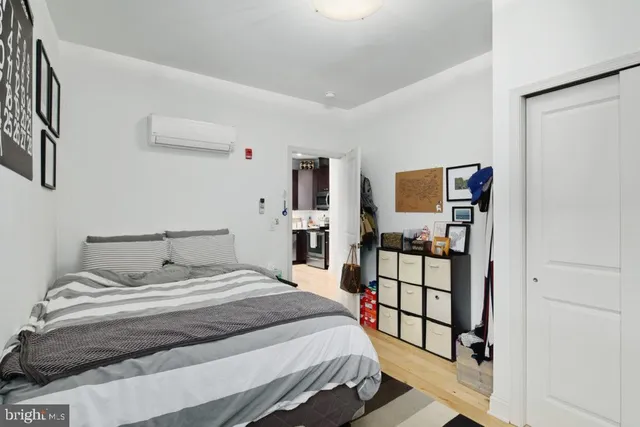 a bedroom with a bed and a flat tv screen on dresser
