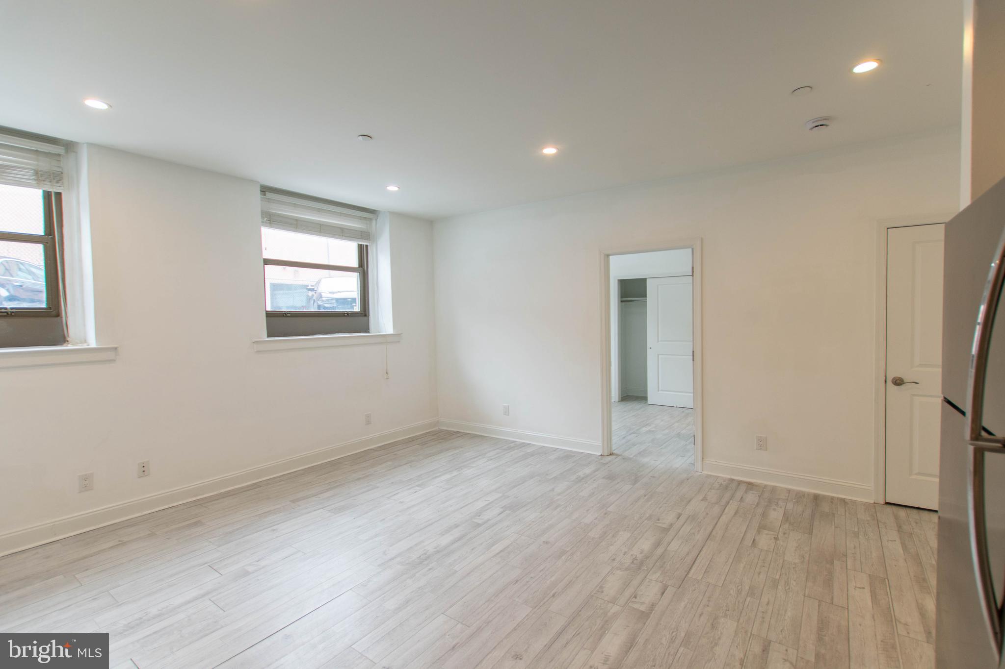 427-33 Monroe Street, Unit 102 Philadelphia, PA 19147 - Photo 10 of 23 an empty room with wooden floor and windows